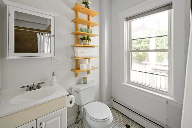 a bathroom with a sink toilet and window