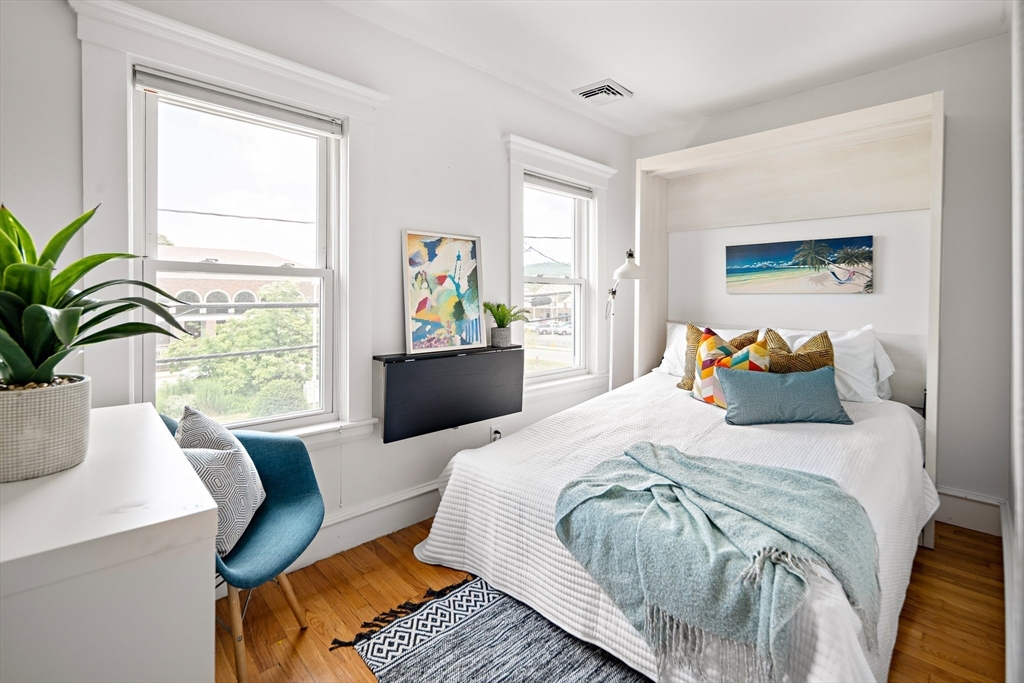 32 Harvard Street, Unit 2 Waltham, MA 02453 - Photo 21 of 32 a bed sitting in a bedroom next to a window with potted plant