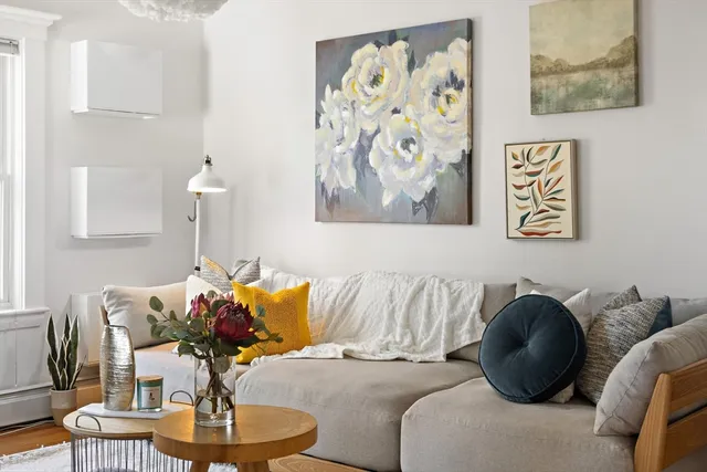 a living room with furniture and painting on the wall