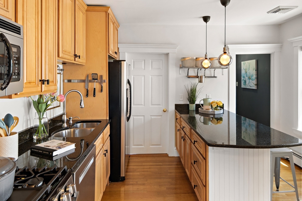 32 Harvard Street, Unit 2 Waltham, MA 02453 - Photo 7 of 32 a kitchen with stainless steel appliances granite countertop a sink stove and refrigerator