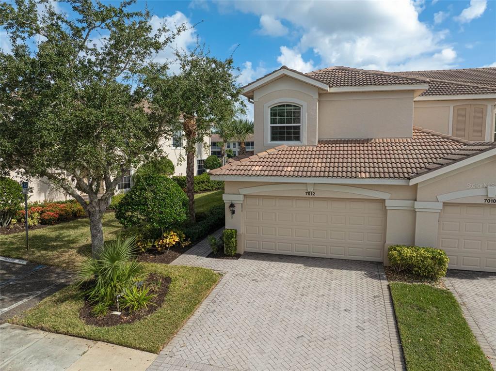 7012 Prosperity Circle, Unit 706 Sarasota, FL 34238 - Photo 34 of 45 a view of a white house with large trees