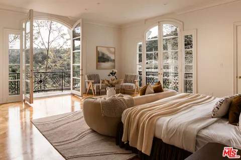 a living room with a bed and a large window