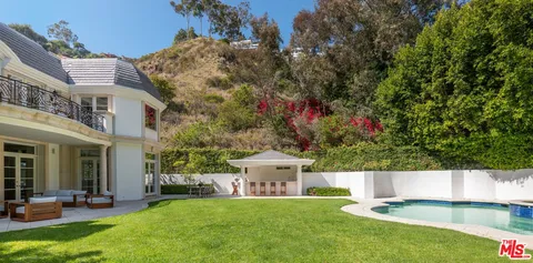 a view of an house with swimming pool and yard