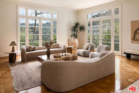 a living room with fireplace furniture and a floor to ceiling window