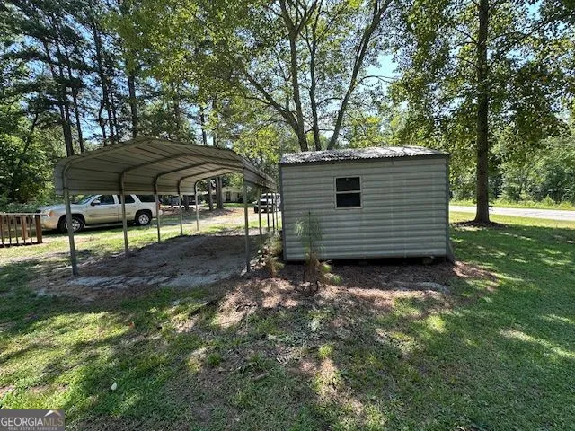 a view of a house with backyard and trees