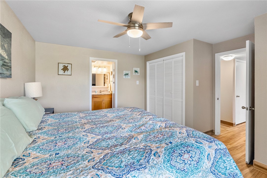 14300 Aloha Street, Unit 139 Corpus Christi, TX 78418 - Photo 13 of 26 a bedroom with a large bed and a chandelier