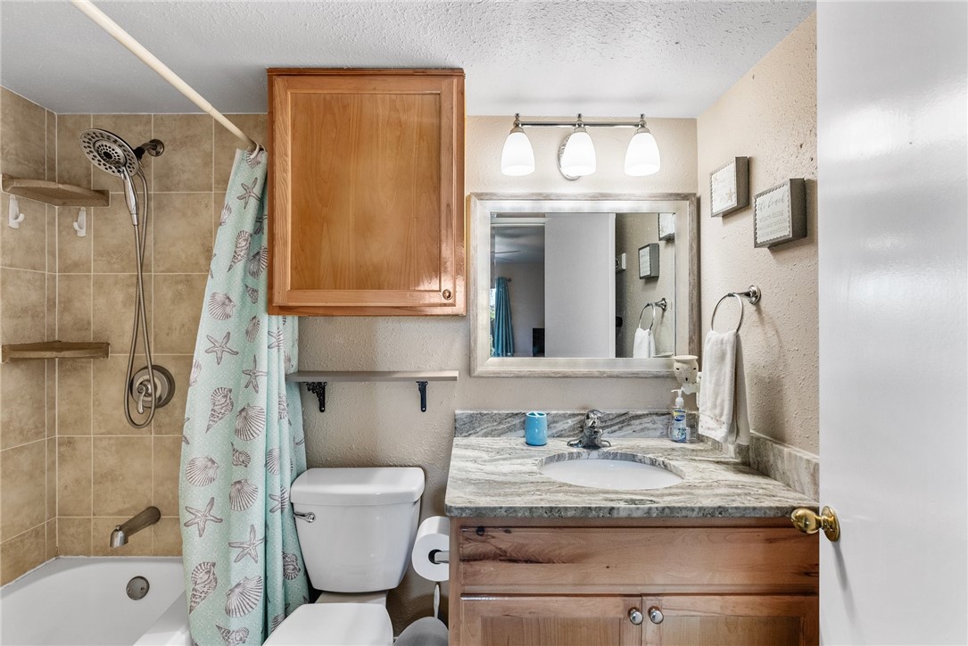 14300 Aloha Street, Unit 139 Corpus Christi, TX 78418 - Photo 15 of 26 a bathroom with a granite countertop sink toilet and shower