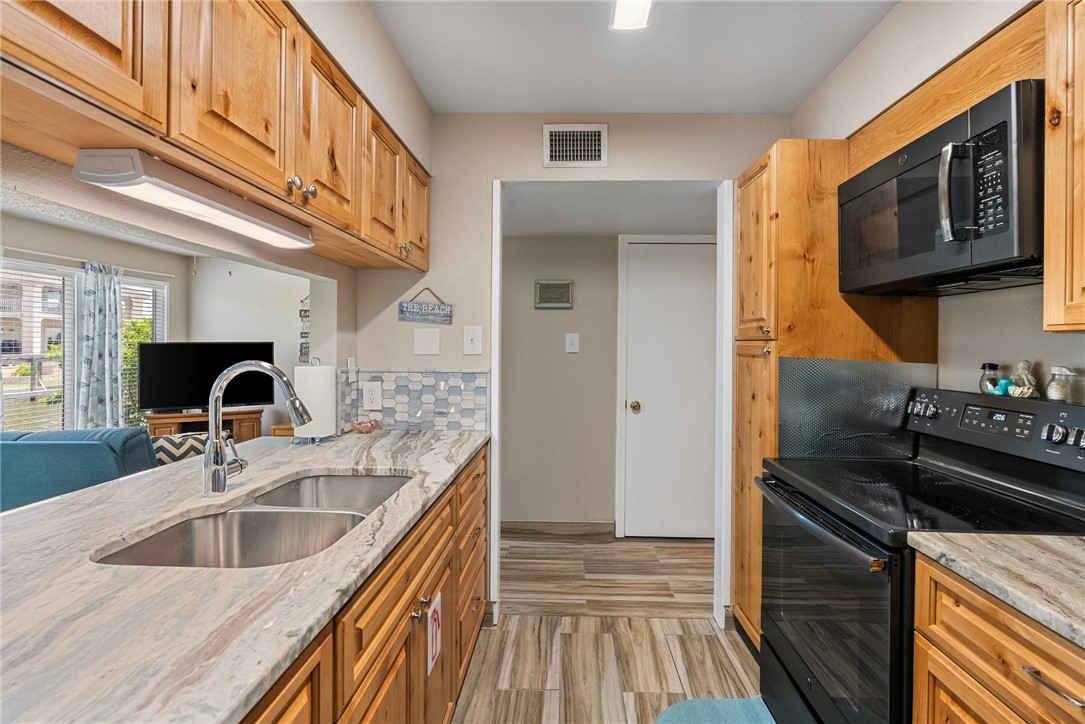 14300 Aloha Street, Unit 139 Corpus Christi, TX 78418 - Photo 19 of 26 a kitchen with a sink cabinets and stainless steel appliances