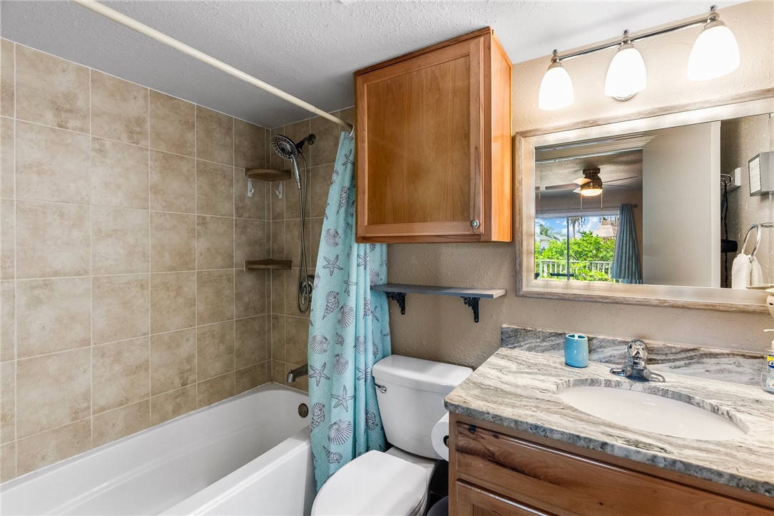 14300 Aloha Street, Unit 139 Corpus Christi, TX 78418 - Photo 8 of 26 a bathroom with a granite countertop sink and a mirror