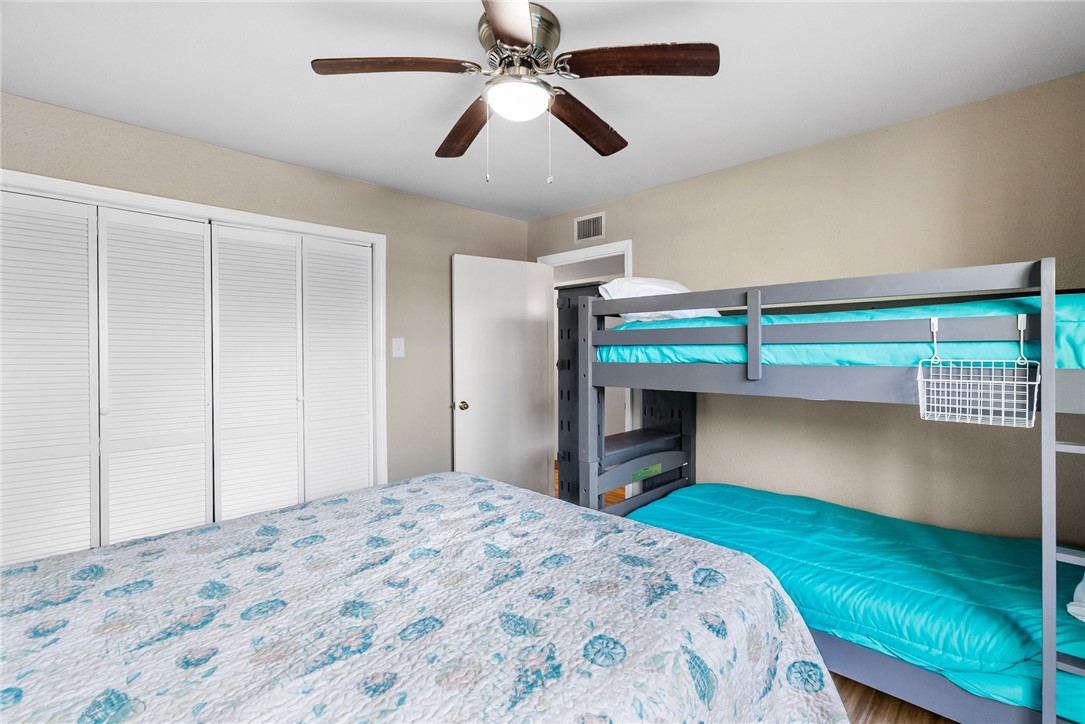 14300 Aloha Street, Unit 139 Corpus Christi, TX 78418 - Photo 10 of 26 a bedroom with a bed and a chandelier fan