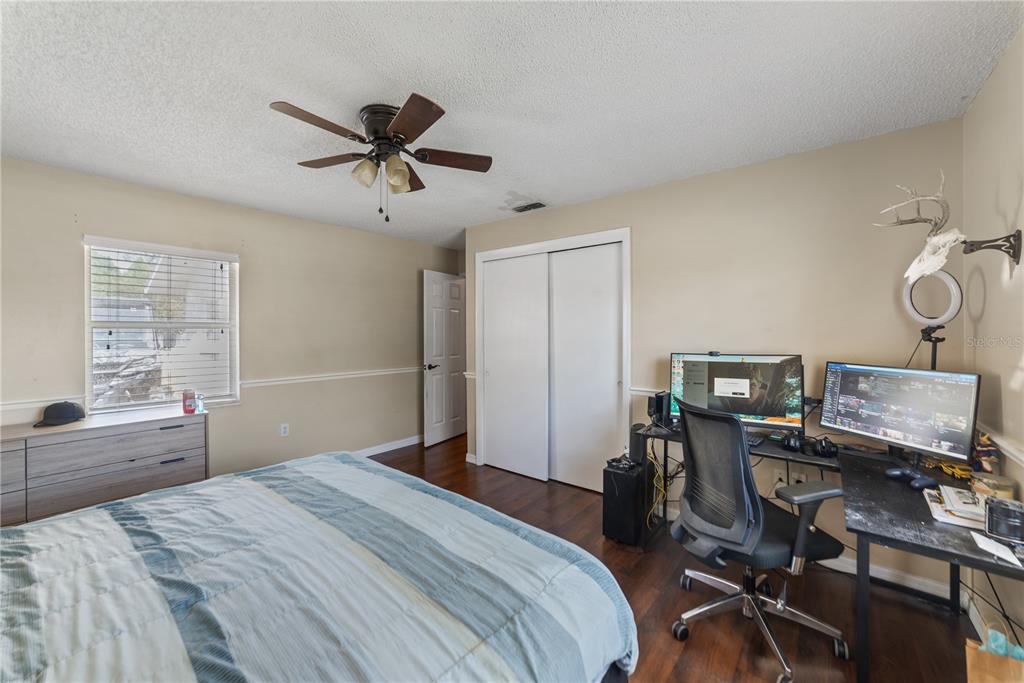 8715 Huntsman Lane Port Richey, FL 34668 - Photo 41 of 54 a bedroom with a bed and a desk