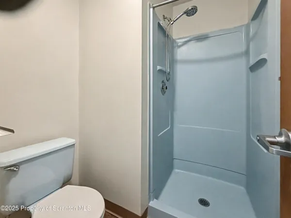 a bathroom with a shower a toilet and a sink