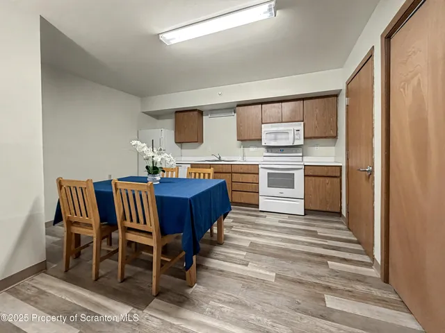 a kitchen with stainless steel appliances granite countertop a table chairs and a refrigerator