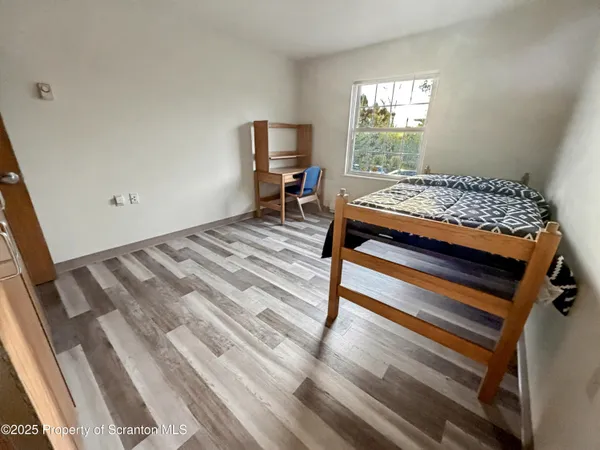 a bedroom with a bed and wooden floor