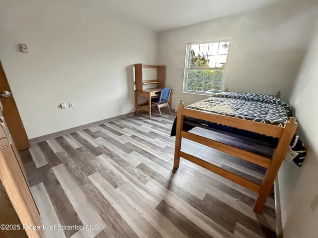 a bedroom with a bed and wooden floor