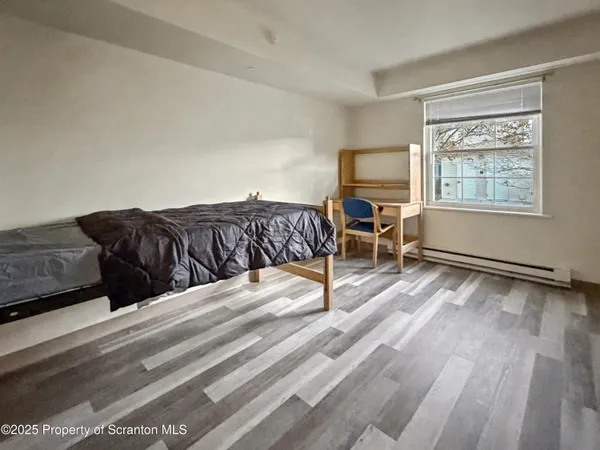 a living room with a bed furniture and next to a window