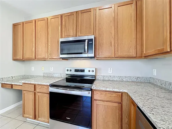 a kitchen with stainless steel appliances granite countertop a refrigerator a sink and a stove