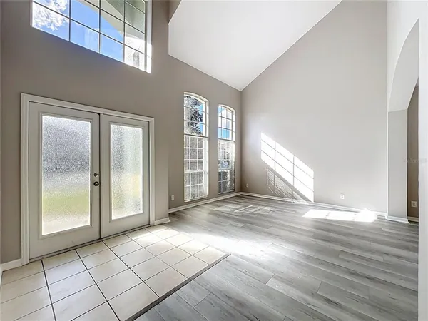 a view of a hallway with wooden floor and a living room