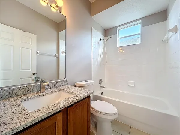 an empty room with window and ceiling fan