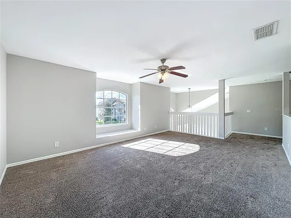 a view of a livingroom with a ceiling fan and window