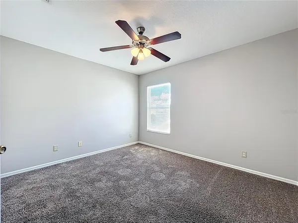 a view of an empty room with a chandelier fan