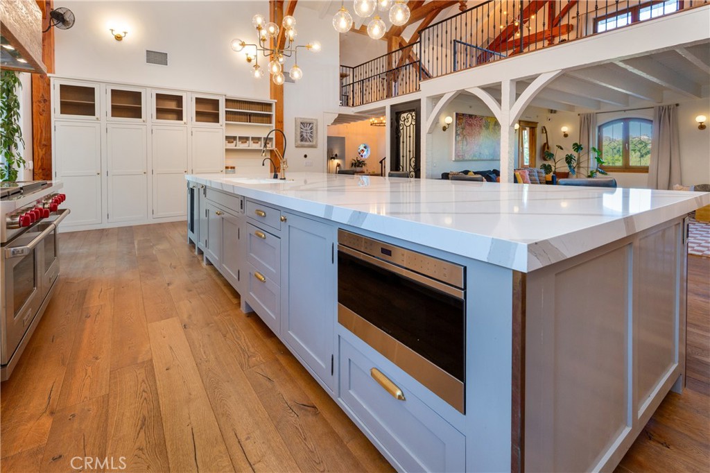 85 Saddlebow Road Bell Canyon, CA 91307 - Photo 6 of 75 a large white kitchen with stainless steel appliances granite countertop a stove and a wooden floors