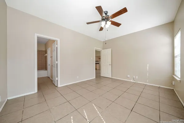 an empty room with closet and a ceiling fan
