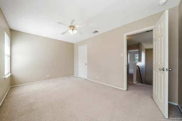a view of an empty room with a ceiling fan