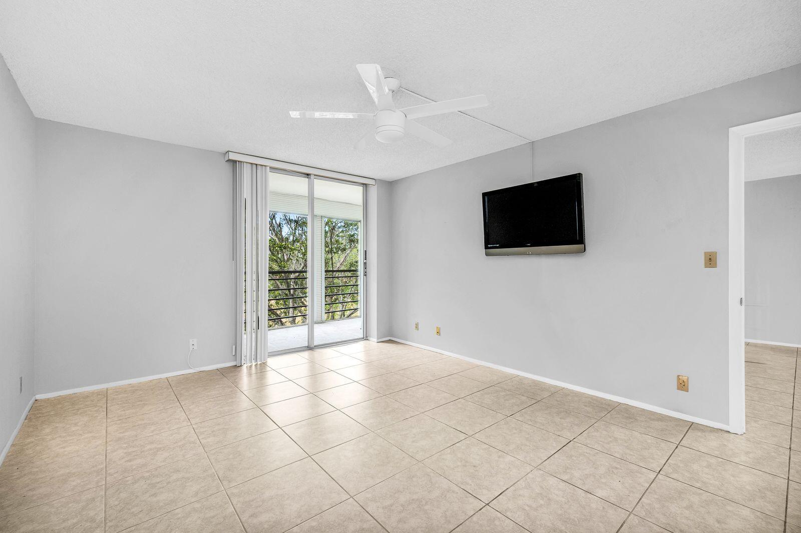 6461 Northwest 2nd Avenue, Unit 403 Boca Raton, FL 33487 - Photo 15 of 22 a view of an empty room with a flat screen tv