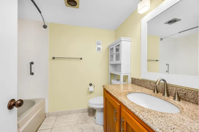 a bathroom with a granite countertop sink toilet and shower