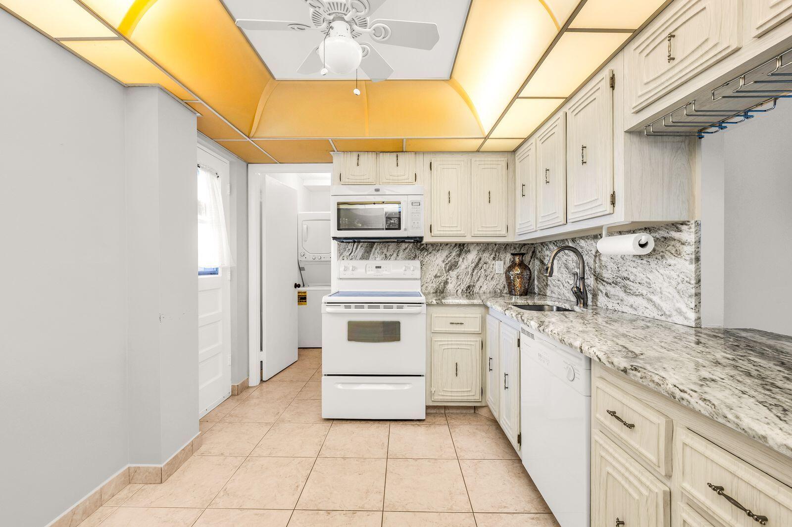 6461 Northwest 2nd Avenue, Unit 403 Boca Raton, FL 33487 - Photo 4 of 22 a kitchen with appliances cabinets and a sink
