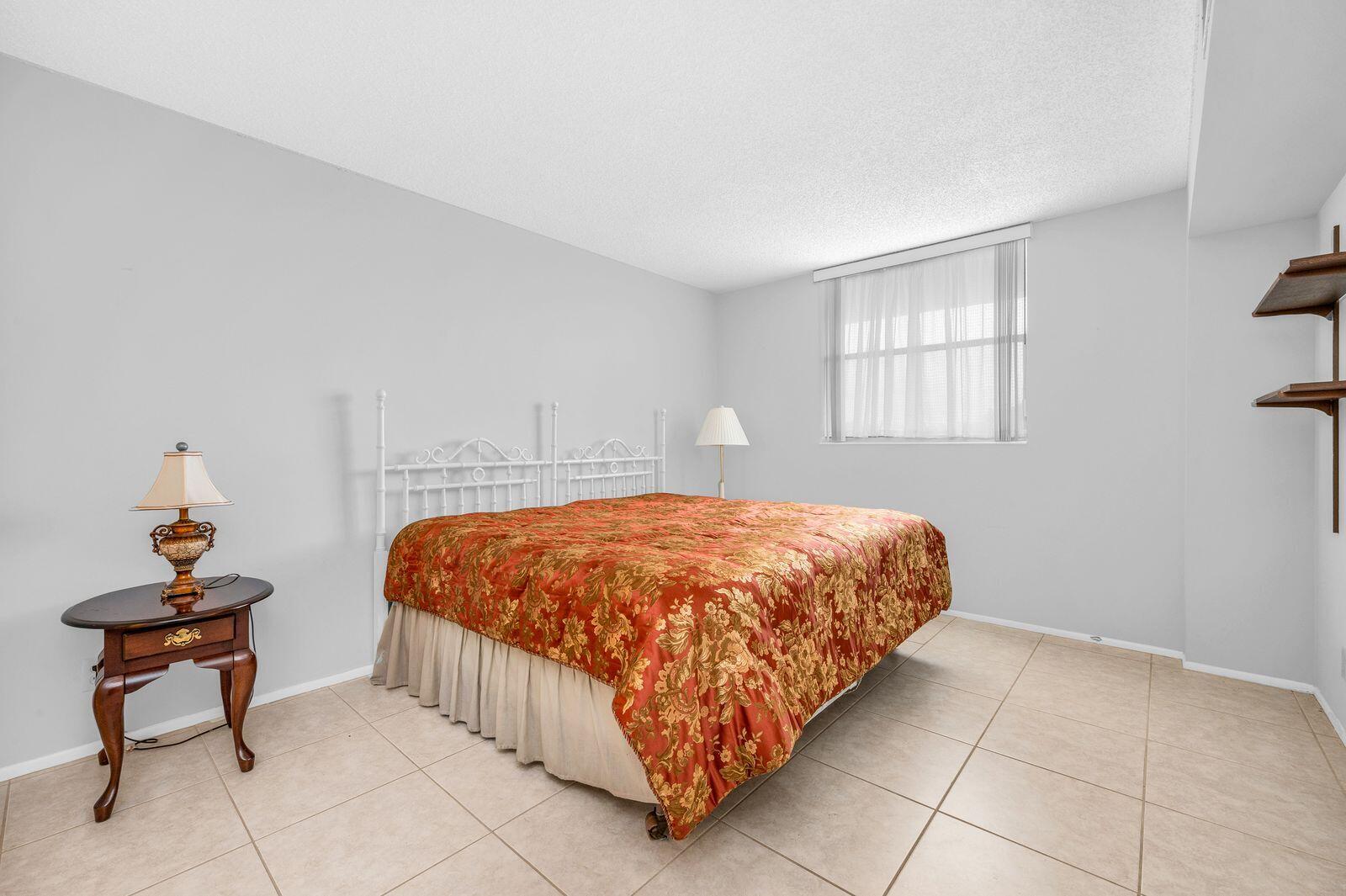 6461 Northwest 2nd Avenue, Unit 403 Boca Raton, FL 33487 - Photo 8 of 22 a bedroom with a bed and a window
