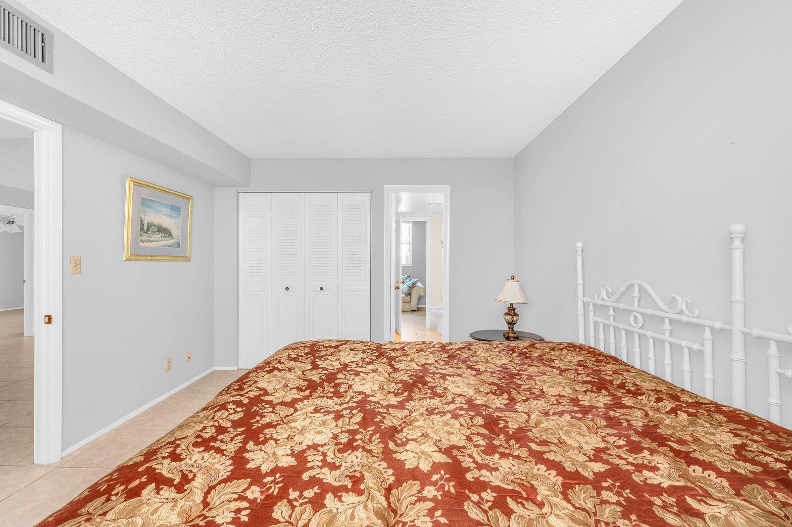 6461 Northwest 2nd Avenue, Unit 403 Boca Raton, FL 33487 - Photo 9 of 22 a bedroom with a bed and a view of bathroom