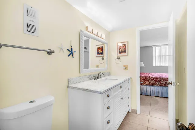 a spacious bathroom with a granite countertop sink a toilet and a mirror