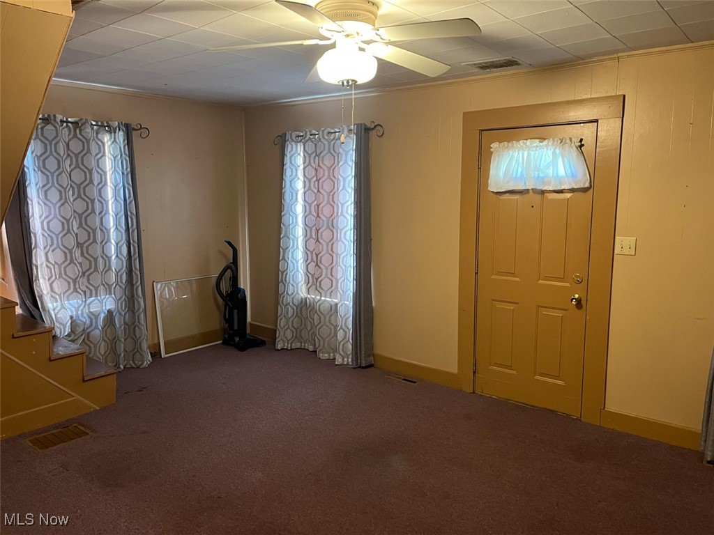2081 Antigua Road Southwest Carrollton, OH 44615 - Photo 8 of 15 Carpeted living room featuring stairs and a ceiling fan