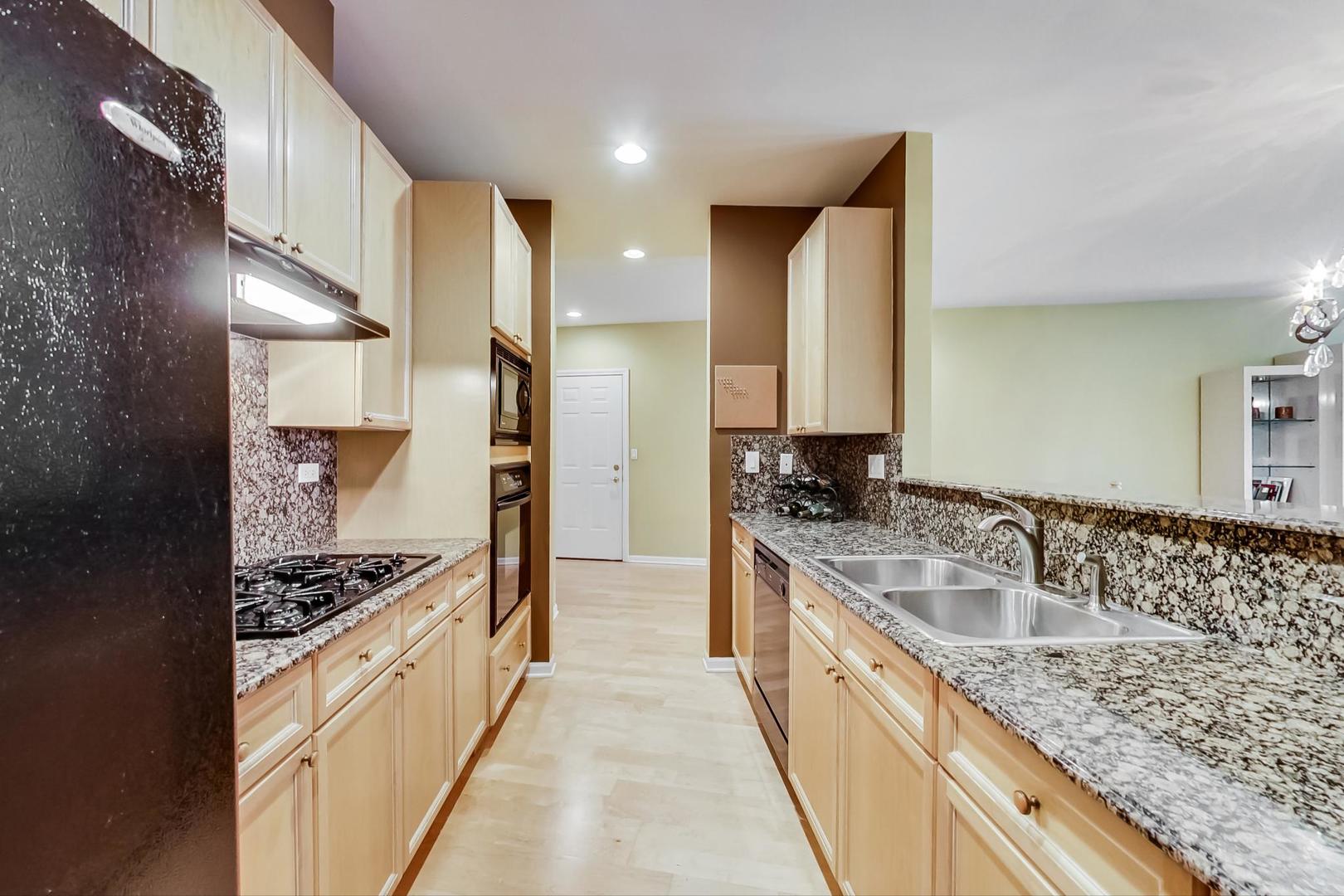 7742 North Sheridan Road, Unit 1L Chicago, IL 60626 - Photo 15 of 40 a kitchen with stainless steel appliances granite countertop a sink stove and refrigerator