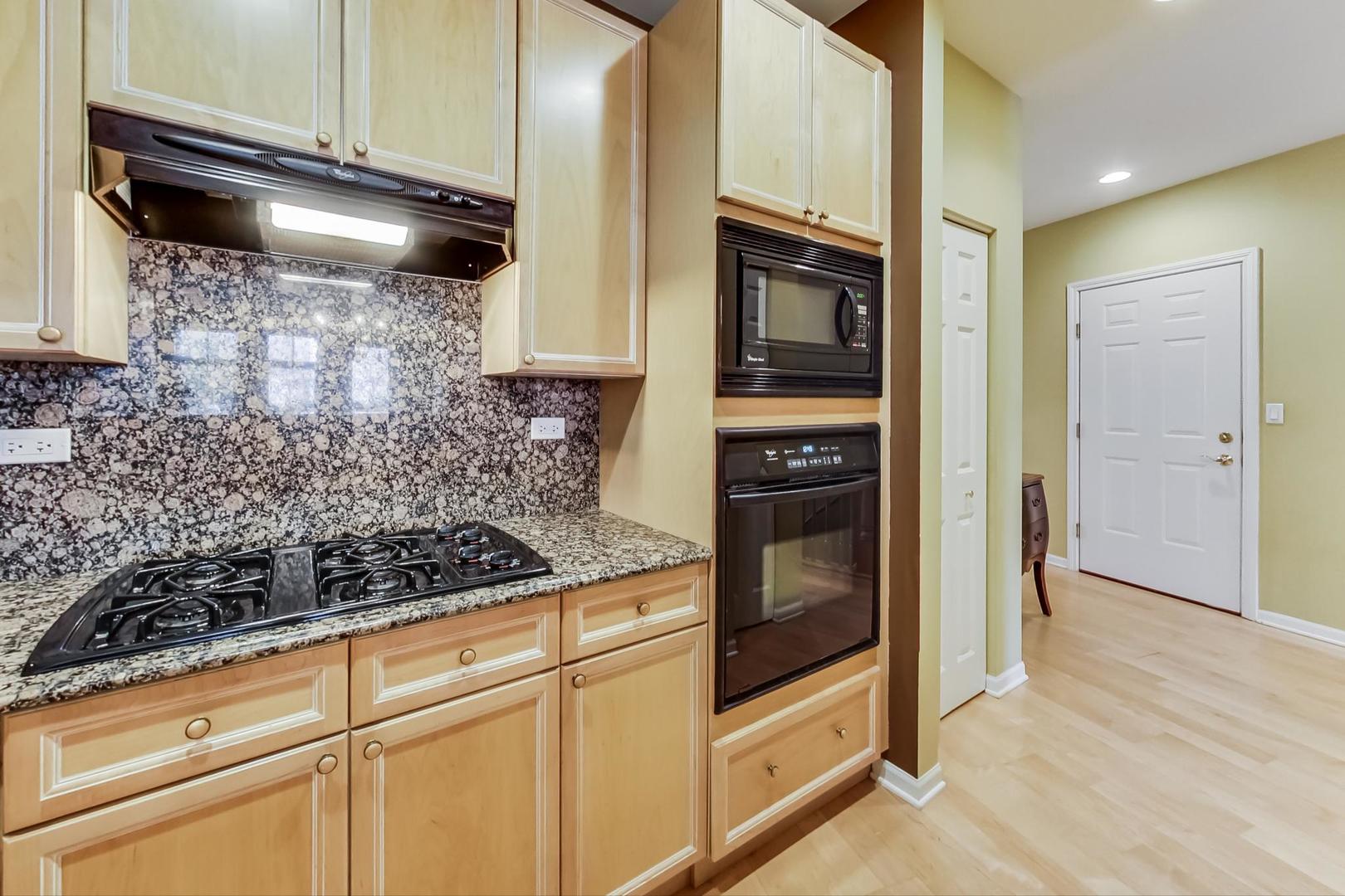 7742 North Sheridan Road, Unit 1L Chicago, IL 60626 - Photo 16 of 40 a kitchen with granite countertop a stove and a microwave