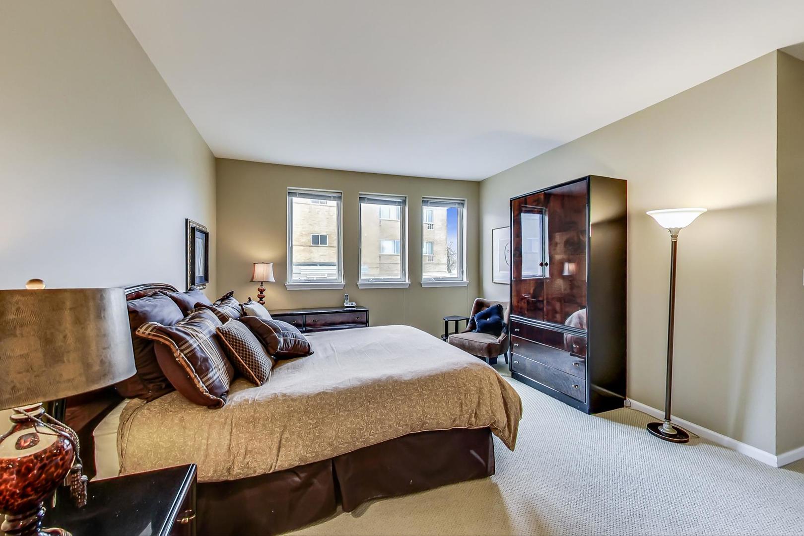 7742 North Sheridan Road, Unit 1L Chicago, IL 60626 - Photo 18 of 40 a bedroom with a bed and a chair