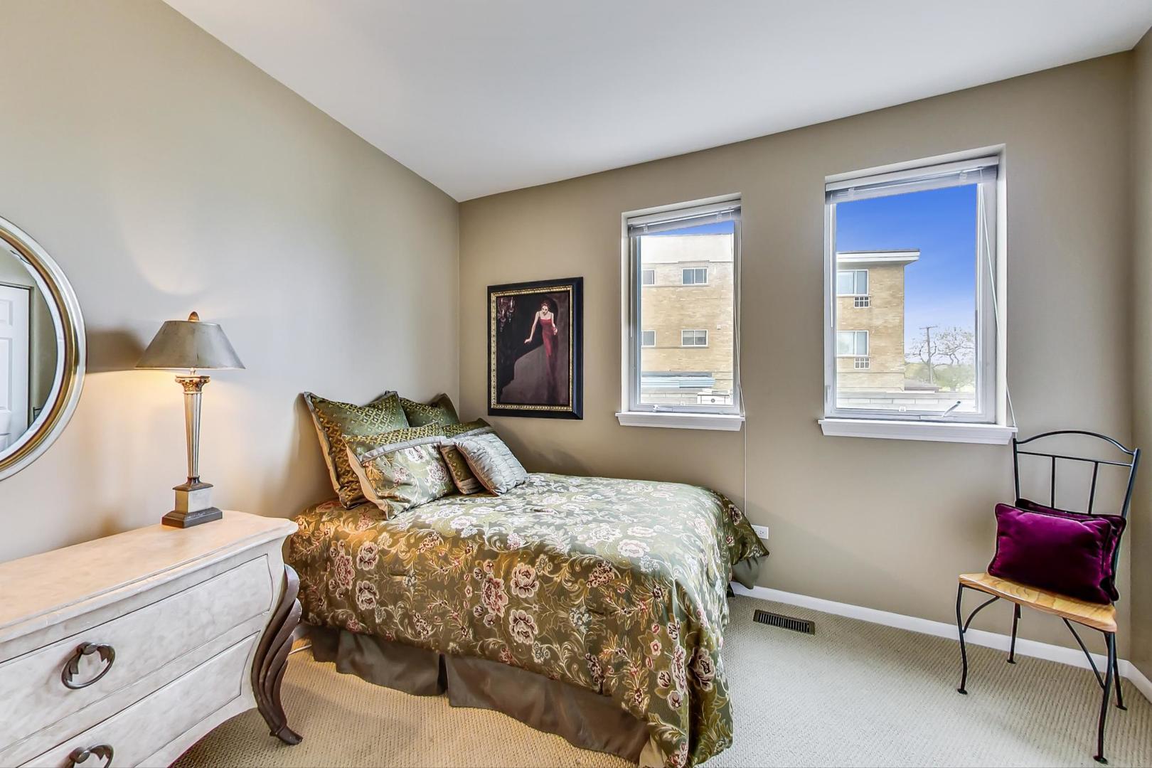 7742 North Sheridan Road, Unit 1L Chicago, IL 60626 - Photo 24 of 40 a bedroom with a bed and a lamp on dresser