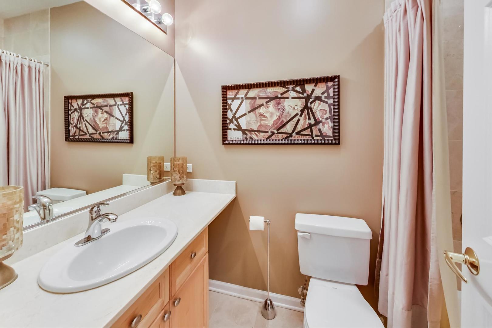 7742 North Sheridan Road, Unit 1L Chicago, IL 60626 - Photo 27 of 40 a bathroom with a toilet a sink and mirror
