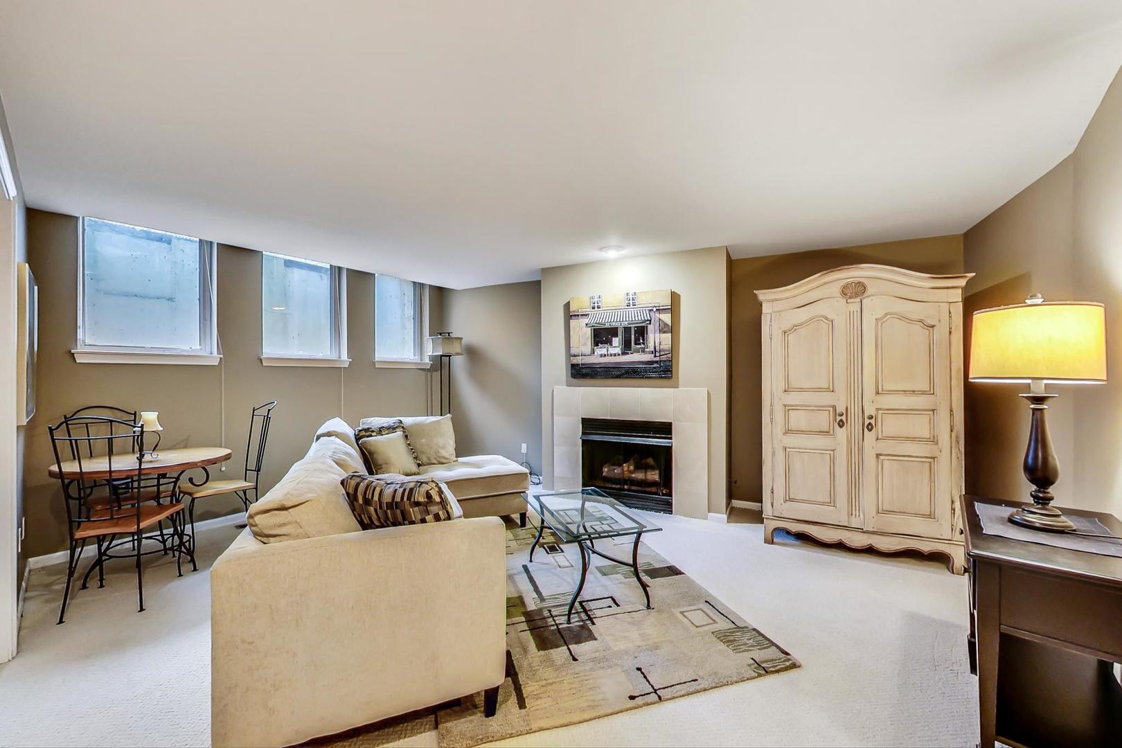 7742 North Sheridan Road, Unit 1L Chicago, IL 60626 - Photo 29 of 40 a living room with furniture a fireplace and a flat screen tv