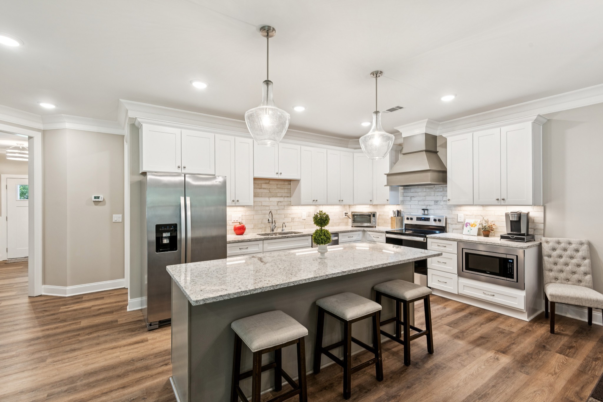 1908 Lucille Street Lebanon, TN 37087 - Photo 5 of 31 a kitchen with stainless steel appliances granite countertop a stove a refrigerator a kitchen island a sink and chairs with wooden floor