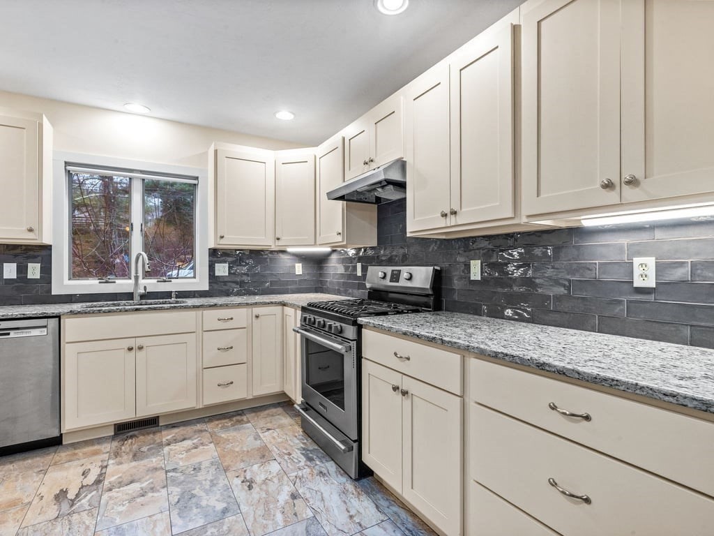 11 Wolf Road Bourne, MA 02532 - Photo 11 of 38 a kitchen with granite countertop white cabinets and stainless steel appliances