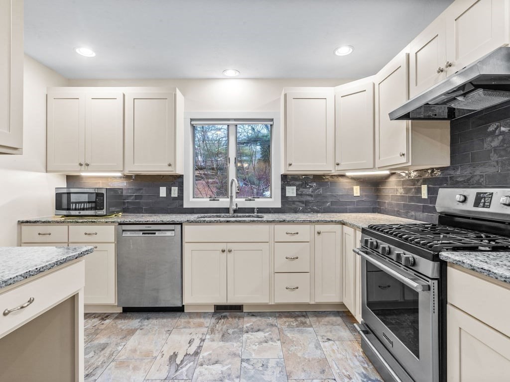 11 Wolf Road Bourne, MA 02532 - Photo 13 of 38 a kitchen with granite countertop a stove sink and cabinets