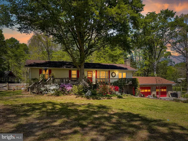 a view of swimming pool with outdoor seating and trees in the background
