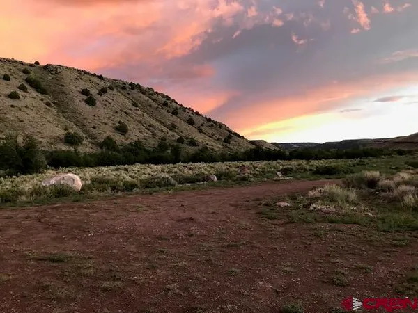 a view of a field with mountains in background