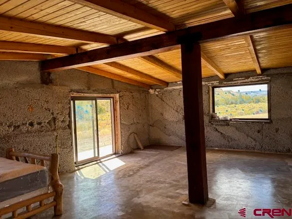 a view of a room with wooden floor and iron stairs