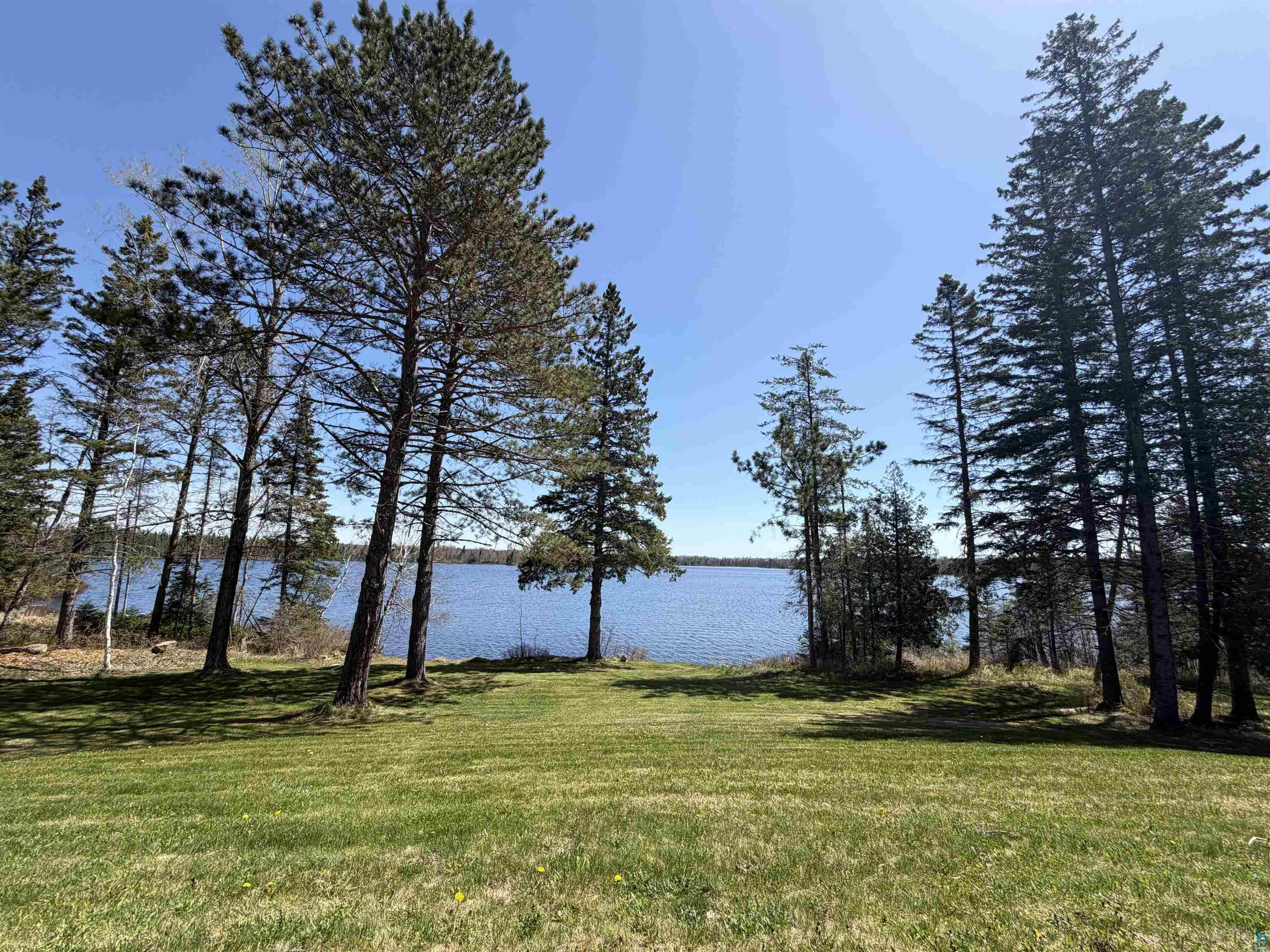 5274 Marble Lake Road Two Harbors, MN 55616 - Photo 61 of 79 Expansive green lawn with mature evergreen trees bordering a tranquil body of water