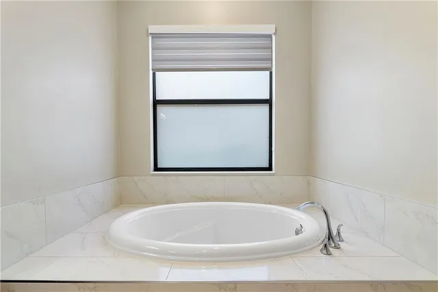 an empty room with wooden floor ceiling fan and windows