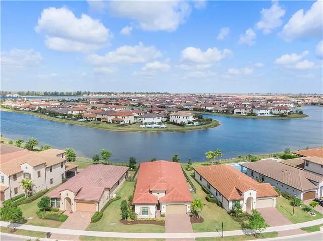 an aerial view of residential houses with outdoor space and lake view